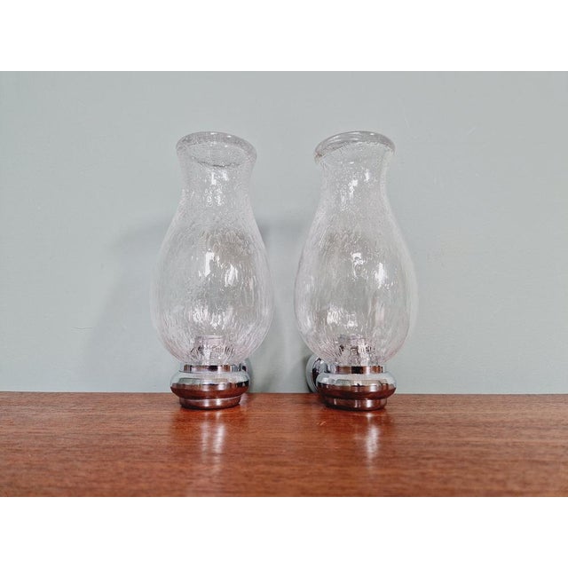 Pair of wall lights in transparent blown glass and chrome metal, 1970s. Very good condition, compatible with an E14 LED...