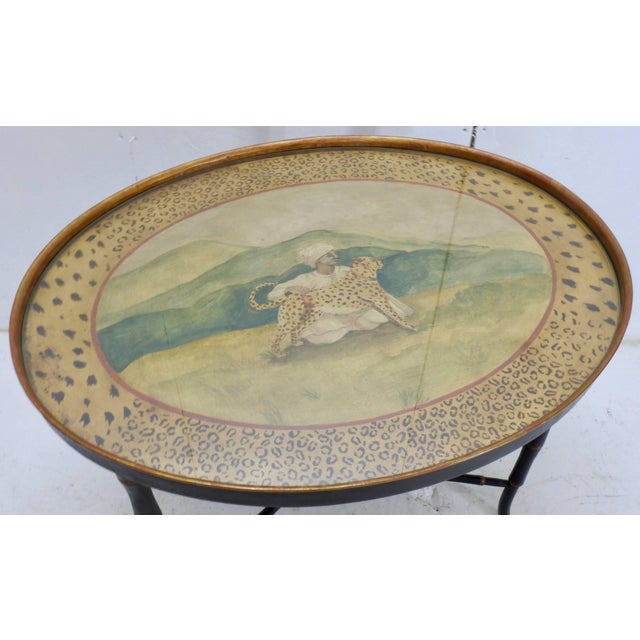 Elegant Chippendale style wooden legs are painted black with gold accents to support the hand-painted oval top. The...