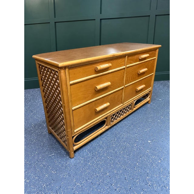 Beautiful vintage bamboo and rattan six-drawer dresser featuring a warm honey-toned finish, sculptural bamboo...