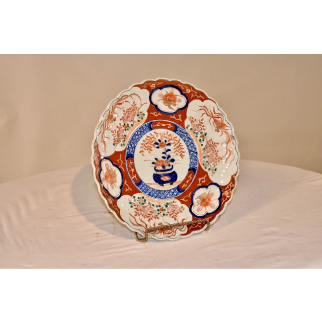 Circa 1900 Imari charger from Japan with a central medallion, containing a hand painted picture of a potted plant,...