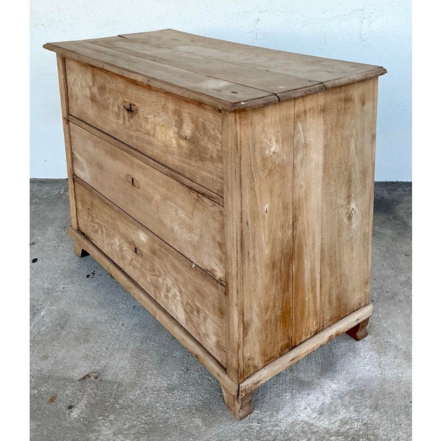 This exceptional 19th-century Biedermeier-style chest of drawers captures the timeless elegance of European neoclassicism...