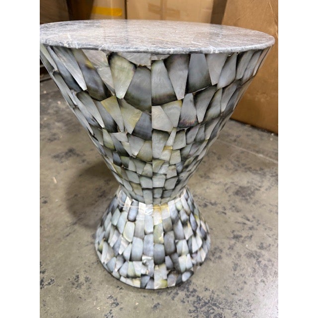 This lovely table is textured to perfection, with a top surface of hand-laid petrified clam stone and a stylish, hour-...