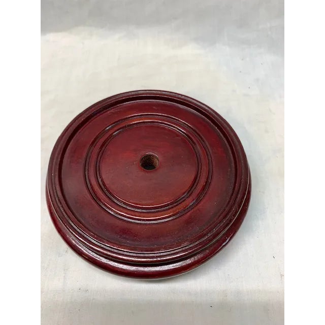 Round wooden stand. Made in the mid 20th century. Overall dimensions: 5.5" x 1.5" 4.75" interior Stained mahogany color