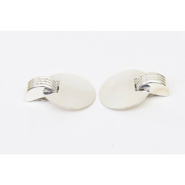These ultra chic and modernist vintage sterling silver clip on dangle disk earrings are from the 60's. They were part of a...