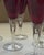 Striking set of six vintage ruby red cordial glasses featuring sculptural clear stems with elegant suspended teardrop...