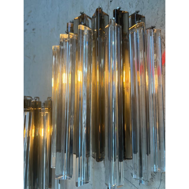 Step into a world of refined elegance with these smoked and transparent Italian glass wall sconces. Each piece is a...