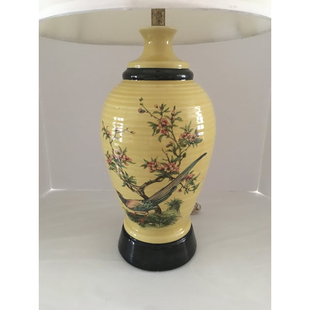 Vintage Yellow porcelain ginger jar lamp with cherry blossoms and pheasant on a black wooden base. Measures 29” to top of...