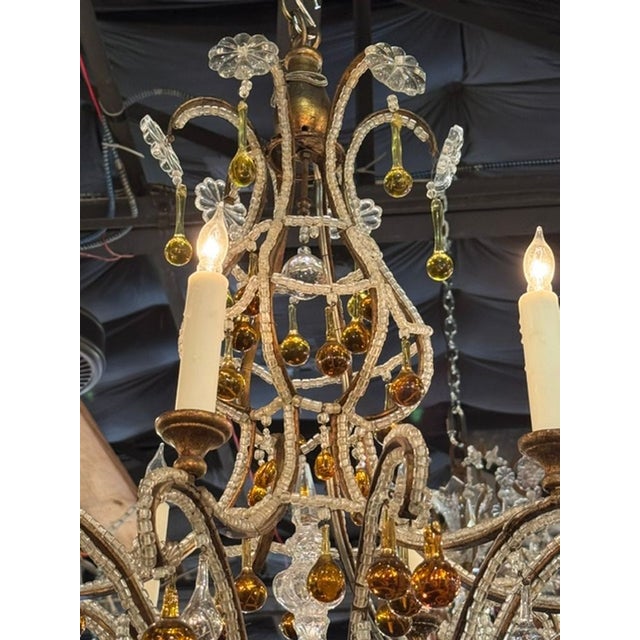 This Vintage Italian Beaded and Amber Chandelier is a beautifully designed lighting fixture that adds a touch of elegance...
