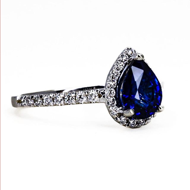 18kw Ring set with one 1.43 carat royal blue pear shape sapphire and 35 round diamonds weighing 0.28 carats. 3.09 grams...
