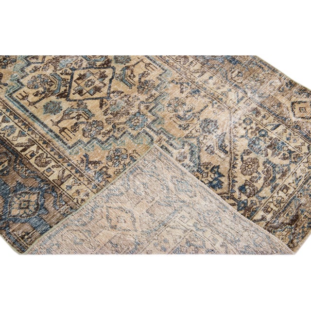 Beautiful vintage Persian distressed hand-knotted wool rug with a beige color field. This piece has a brown frame and navy...