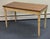 Elegant Neoclassical-style writing table featuring a warm wood top with a finely outlined inset border, beautifully...
