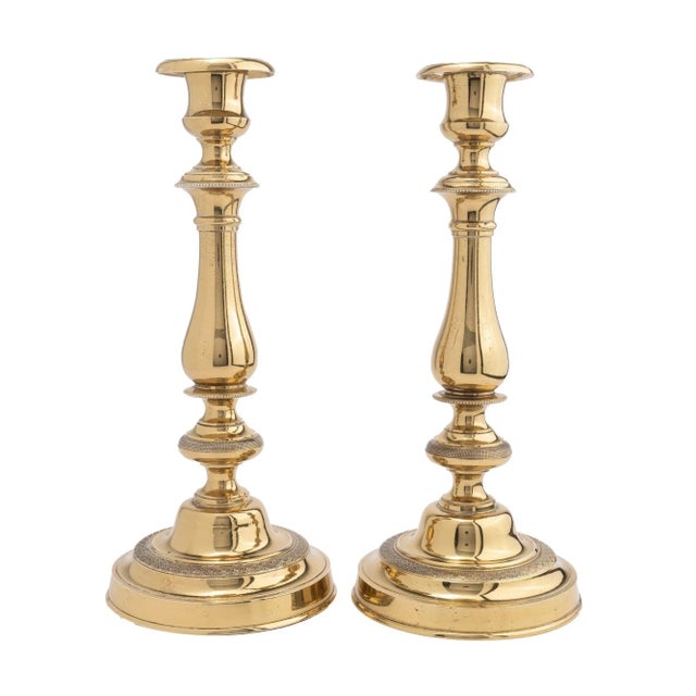 Pair of cast brass, engine turned, French Empire period candlesticks. The pear shaped candle shaft are framed by beaded...