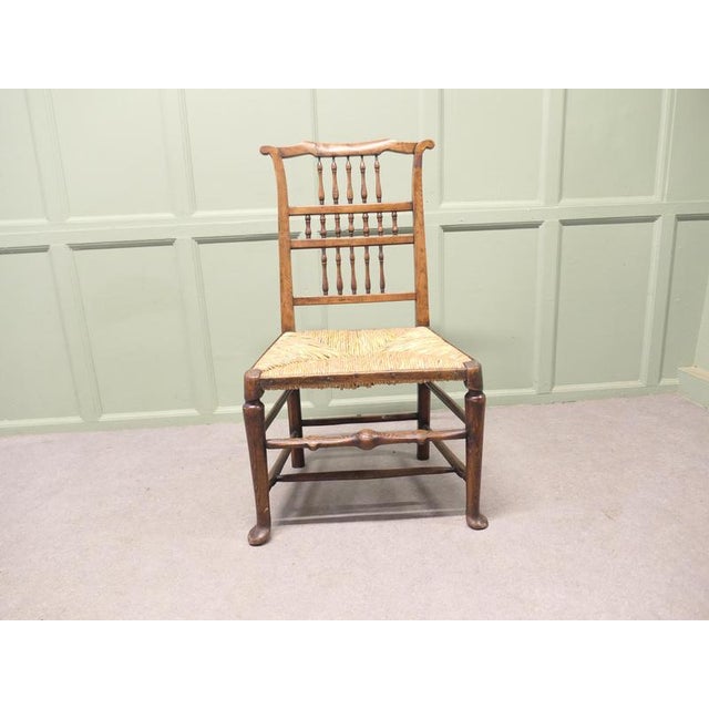 This is a very attractive chair with a turned 3 layer spindle back it has sturdy pad feet and a turned chunky front...