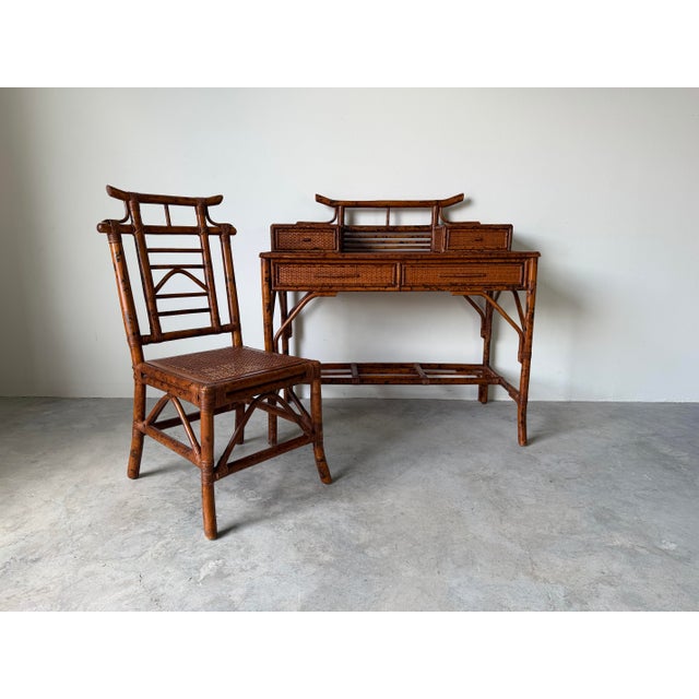 A beautifully crafted vintage desk and chair set in the timeless British Colonial style, featuring faux bamboo framing and...