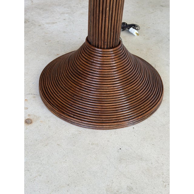 An extraordinary vintage rattan palm tree floor lamp featuring ten beautifully sculpted palm fronds and three hanging...