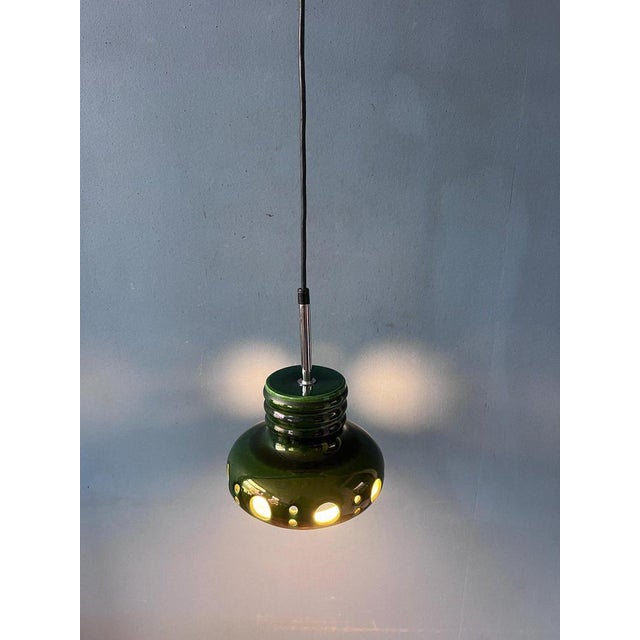 Green West Germany ceramic UFO pendant lamp in a deep dark green color. Light beautifully escapes from underneath the...