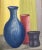 MCM painting depicting a collection of vases on a color block ground. The artist painted with heavy textured strokes to...