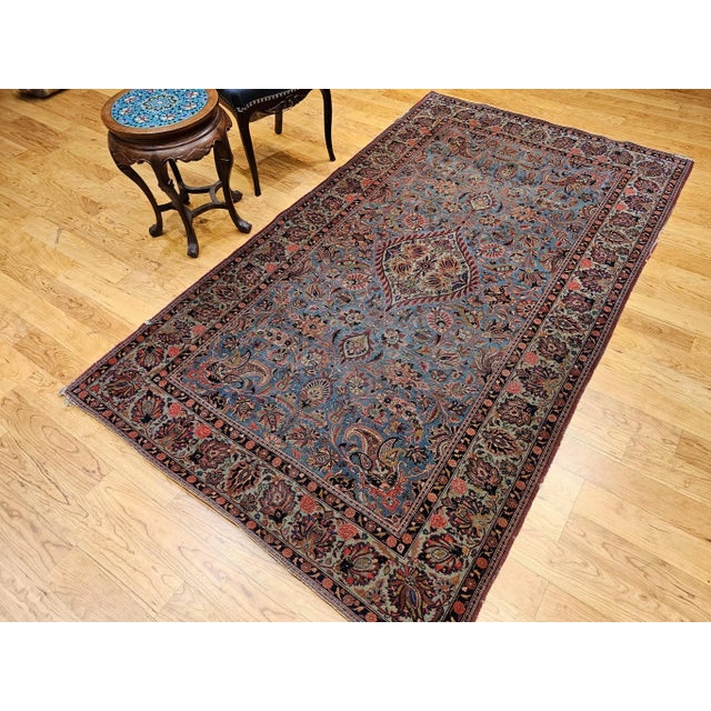 4’ 7” x 8’ 1” Vintage hand knotted Persian Kashan area rug in floral pattern set on a wonderful aqua blue field color and...