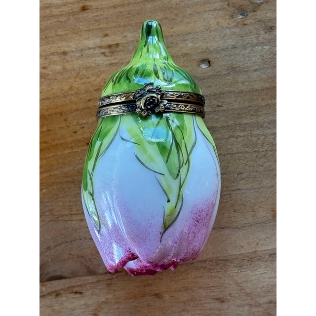 Vintage Limoges trinket box modeled as a closed rosebud, green sepals wrapping down over pale petals that blush to pink...