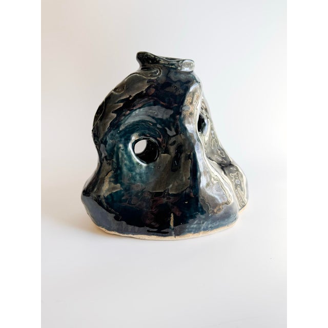 A striking hand-built ceramic art vessel signed ISA, featuring a deeply expressive, organic form with sculptural contours...