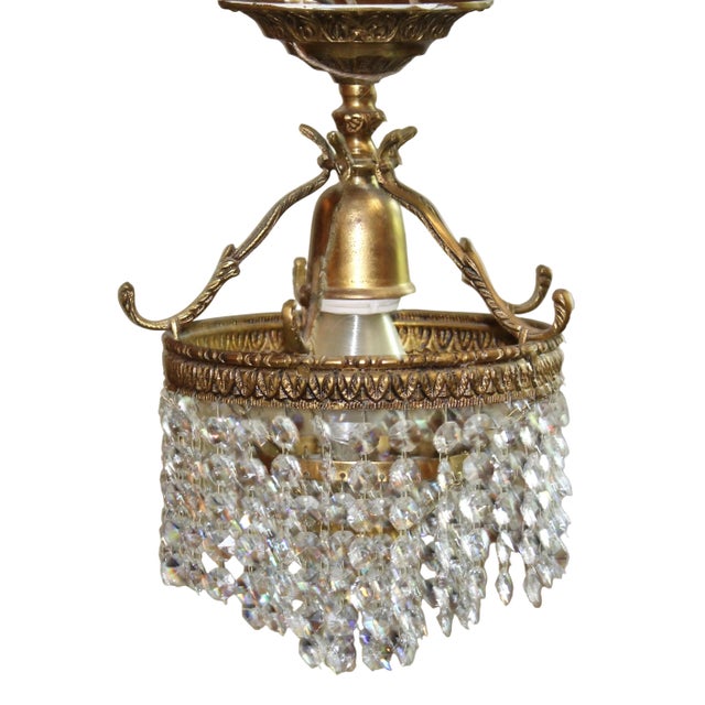 Crafted with an ornate brass frame, it features a decorative scrolled crown accent and detailed relief patterning along...