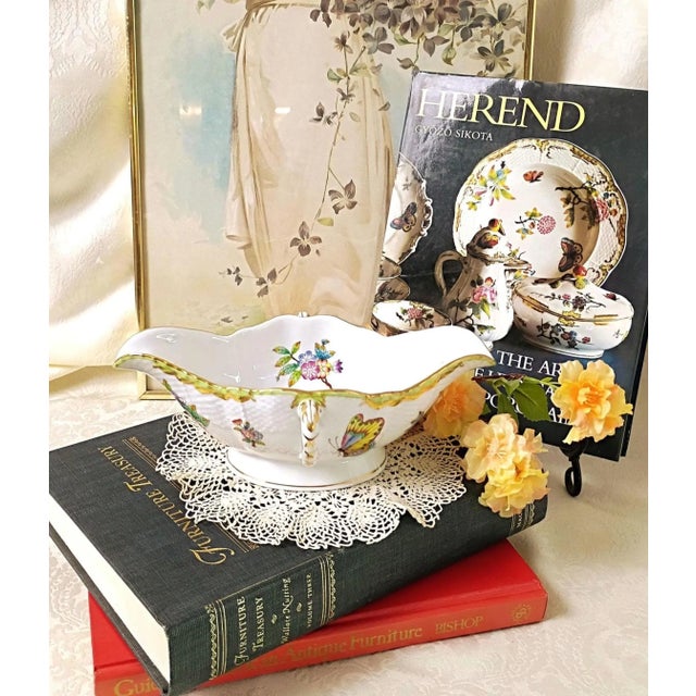 This classic hand-painted double spouted porcelain sauce boat represents the historic artistic legacy of the Herend...