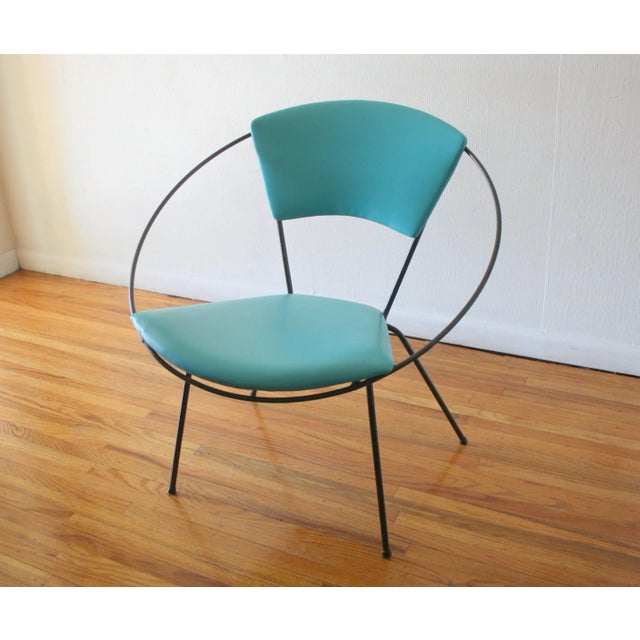 This is a mid century modern hoop chair designed by Joseph Ciccelli for Reilly-Wolff. It has a round wrought iron base...