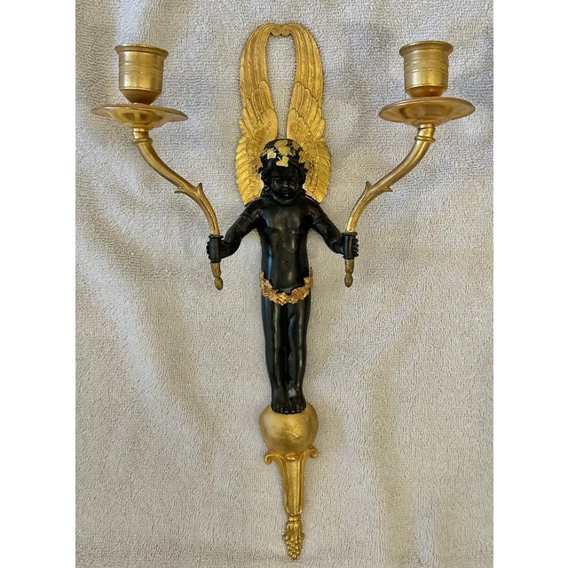 Set of Four Gilt and Patinated Bronze Cherub Two Arm Wall Sconces. Well-executed winged cherubs with ivy head wreaths...