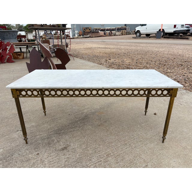 French Louis XVI Style Brass And Marble Cocktail Table. Offered is a glamorous French Louis XVI style rectangular brass...