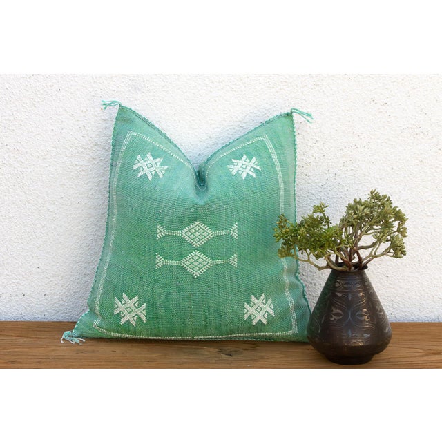 A crisp white star motif sits above a double-row dotted border on this handcrafted Moroccan cactus silk pillow, hand-...