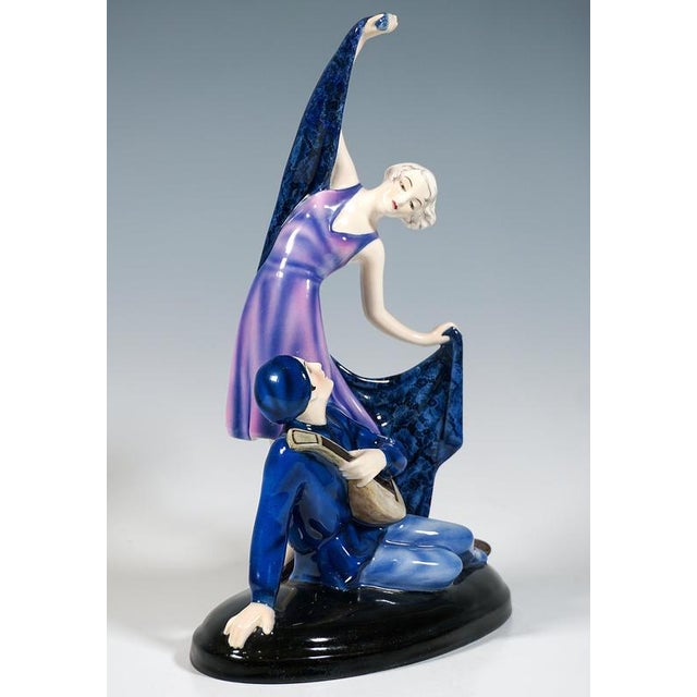 Exquisite ceramic figurine group of the 1930: a delicate young dancer with an ash-blonde pageboy haircut, wearing a long,...