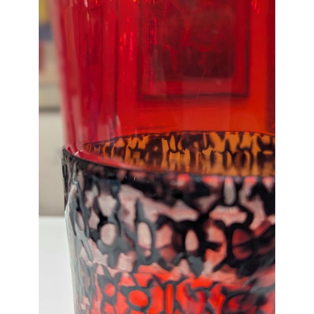 Late 20th-century hand-blown glass vessel in saturated ruby with a textured central band featuring black filigree.
