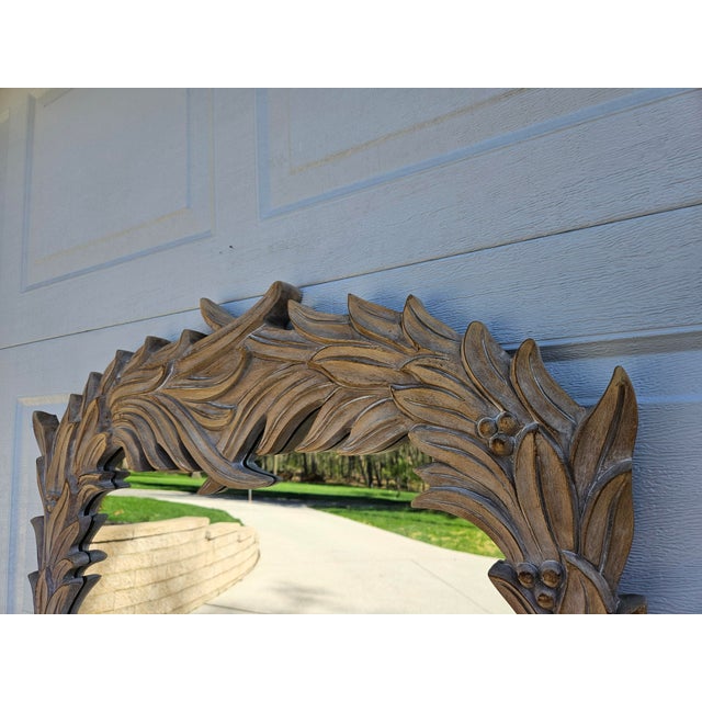 A classic palm and berry wall mirror with a whitewashed finish. This piece is in the style of Serge Roche but bears no...