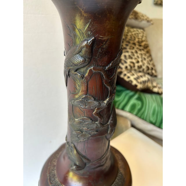 An antique Japanese Meiji period Bronze vase, lamp, features detailed relief carvings of birds and natural motifs...