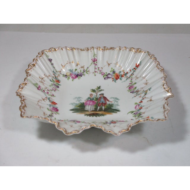 German Dresden porcelain bowl with ruffled sides. It is hand painted and decorated with a courting couple surrounded with...