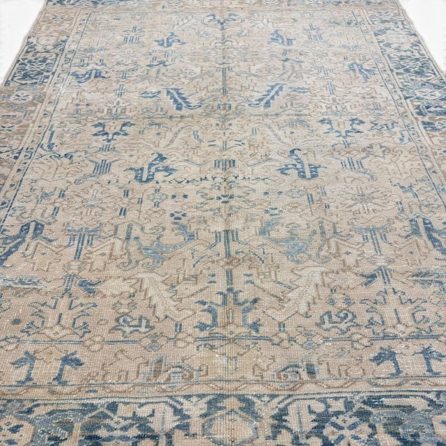This antique Heriz rug showcases the distinctive geometric and stylized design language of the Heriz tradition in a...