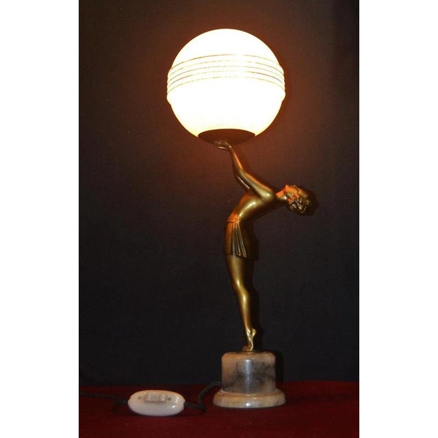 A striking French Art Deco figural table lamp dating to circa 1930, combining sculptural elegance with the atmospheric...