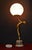 A striking French Art Deco figural table lamp dating to circa 1930, combining sculptural elegance with the atmospheric...