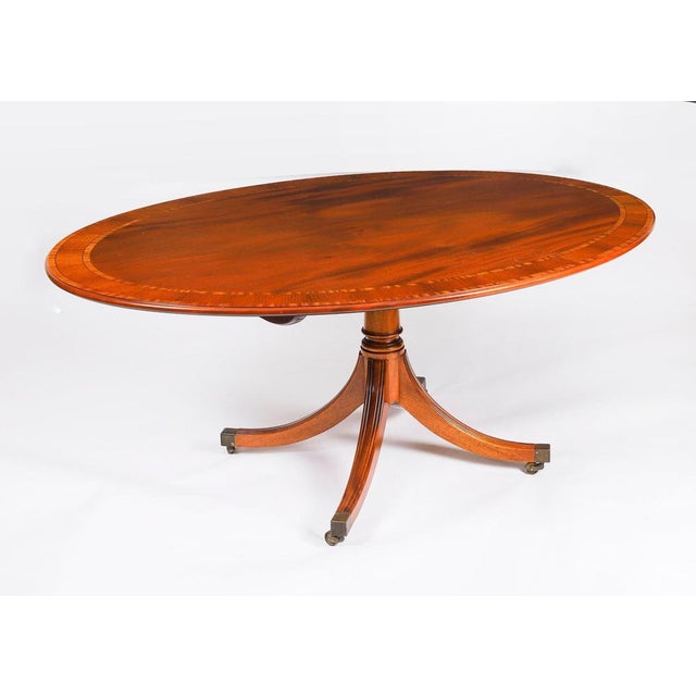 This is a beautiful regency revival flame mahogany and satin wood banded oval dining table and a set of six shield back...