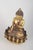 Gilt bronze Buddha figure. Seated Buddha figure executed in gilt bronze with one hand raised in a symbolic gesture and...
