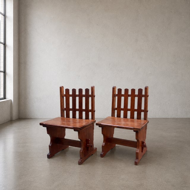 A fabulous and highly individual pair of handcrafted solid mahogany chairs, combining bold construction with a distinctly...