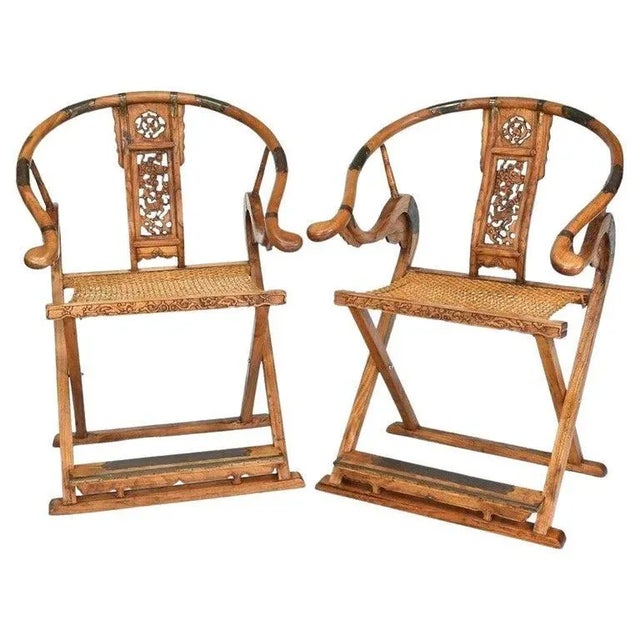 A remarkable pair of late 19th-century Chinese solid elmwood horseshoe hunting chairs, known as Jiao-Yi. These chairs,...