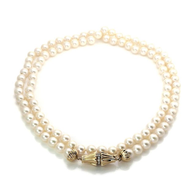 This elegant vintage necklace has a long single strand pearls. It has a lovely fancy design fluted clasp with round cut...