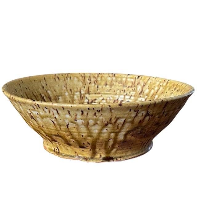 Signed vintage studio pottery bowl featuring a warm speckled glaze with expressive drip patterning in earthy ochre and...