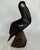 Vintage carved dark wood pelican figurine. The wood surface of the pelican has a very smooth satin texture; the...