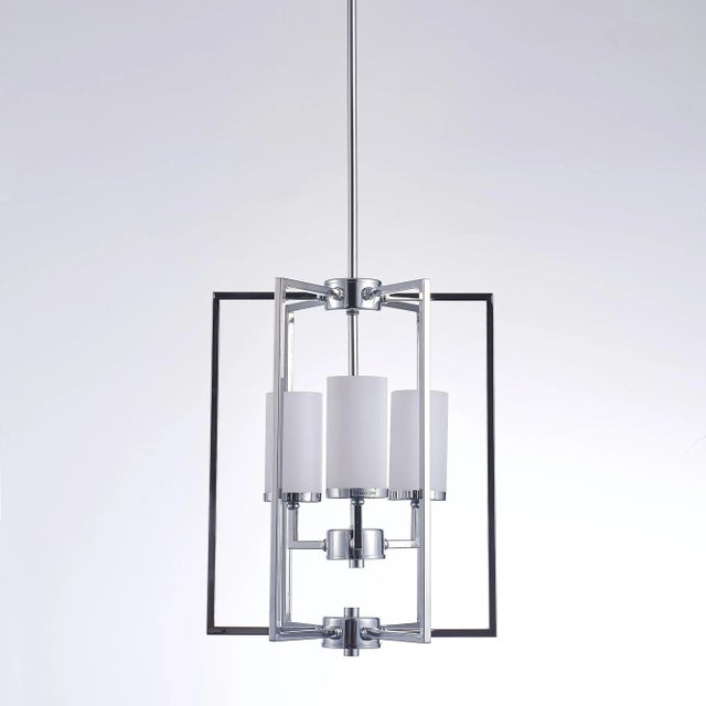 The Riva chandelier features frosted glass lights elegantly encased within a polished chrome frame. This sleek design...