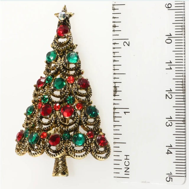 Vintage Christmas tree with traditional red and green rhinestones. Metal is gold plated. Marked Pakula. We believe this...