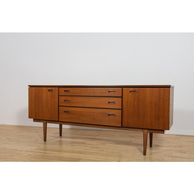 This teak sideboard was manufactured by the British furniture maker Nathan Furniture during the 1960s. The piece...