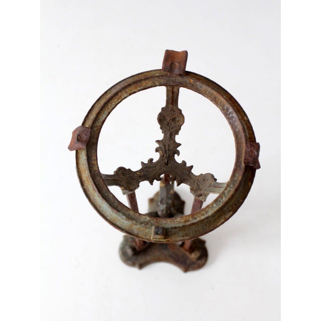 This antique Gothic Revival iron plant stand features a tall architectural form with pierced scrollwork and quatrefoil-...