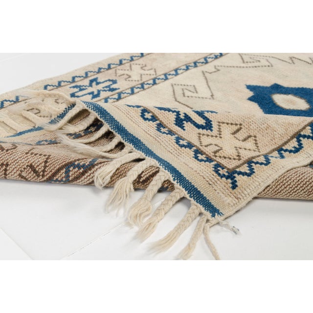 This is a vintage Turkish Oushak rug from the Mid 20th Century. The piece was hand-knotted.